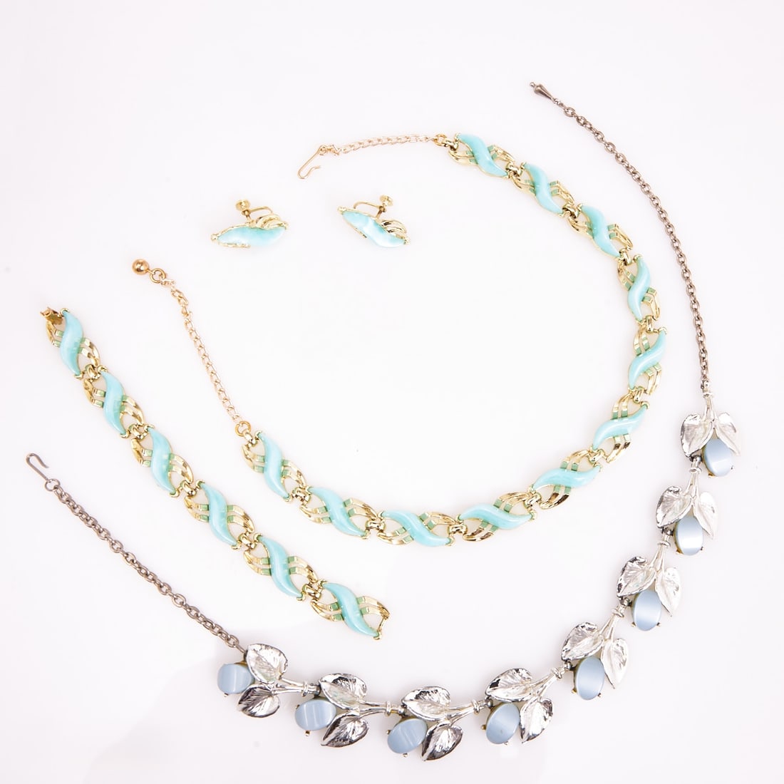 Vintage Thermoset Parures in Blue and Turquoise Tones: Vintage Thermoset Parures in Blue and Turquoise Tones (4 pieces) 2 necklaces, 1 bracelet, and 1 pair of clip-on earrings. Probably USA, circa 1950s. Metal, gold- / silver-colored; Thermoset. Weight: 1