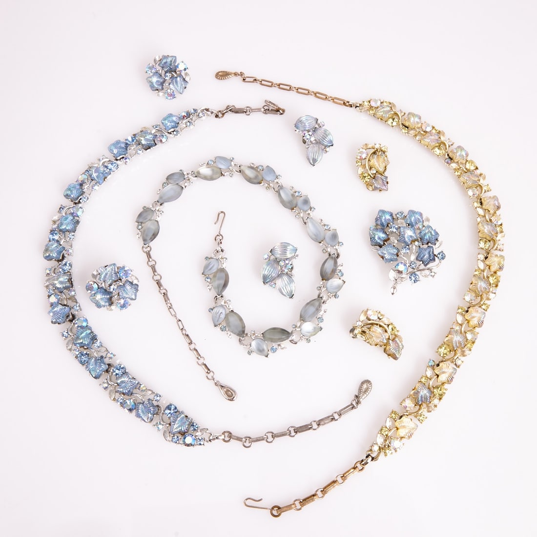 LISNER - Three vintage parures with leaf motifs (7 pieces): LISNER - Three vintage parures with leaf motifs (7 pieces) 3 necklaces, 1 brooch and 3 pairs of ear clips. Lisner, New York, circa 1950. Metal, gold- / silver-colored; rhinestones; glass; Lucite. Tota