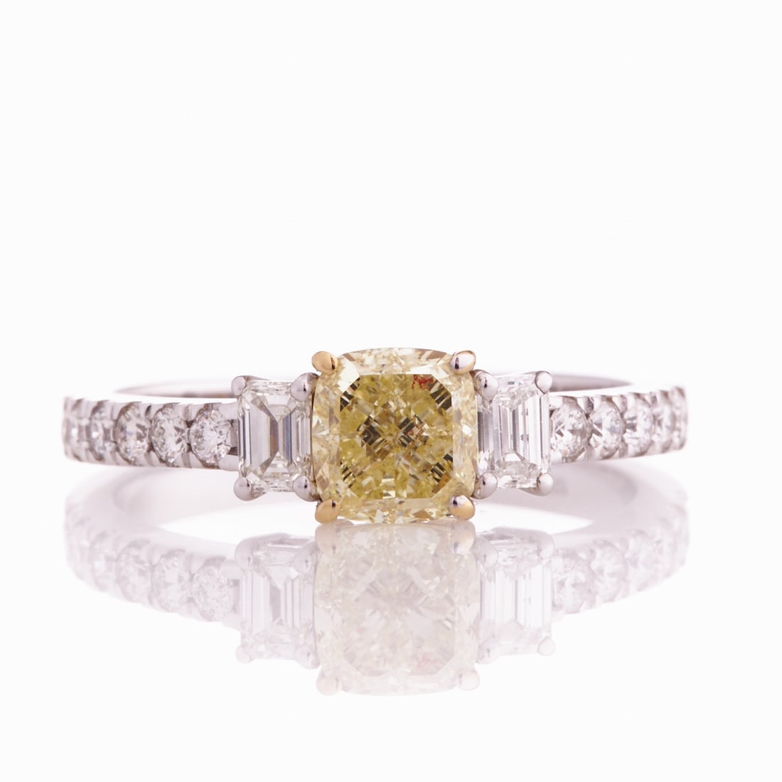Fancy Yellow Diamond Ring: Fancy Yellow Diamond Ring 750/- white gold and yellow gold, stamped. Total weight: 4 g. 1 Fancy diamond in cushion cut approx. 1.01 ct (Light Yellow, si1). 2 baguette-cut diamonds totaling approx.
