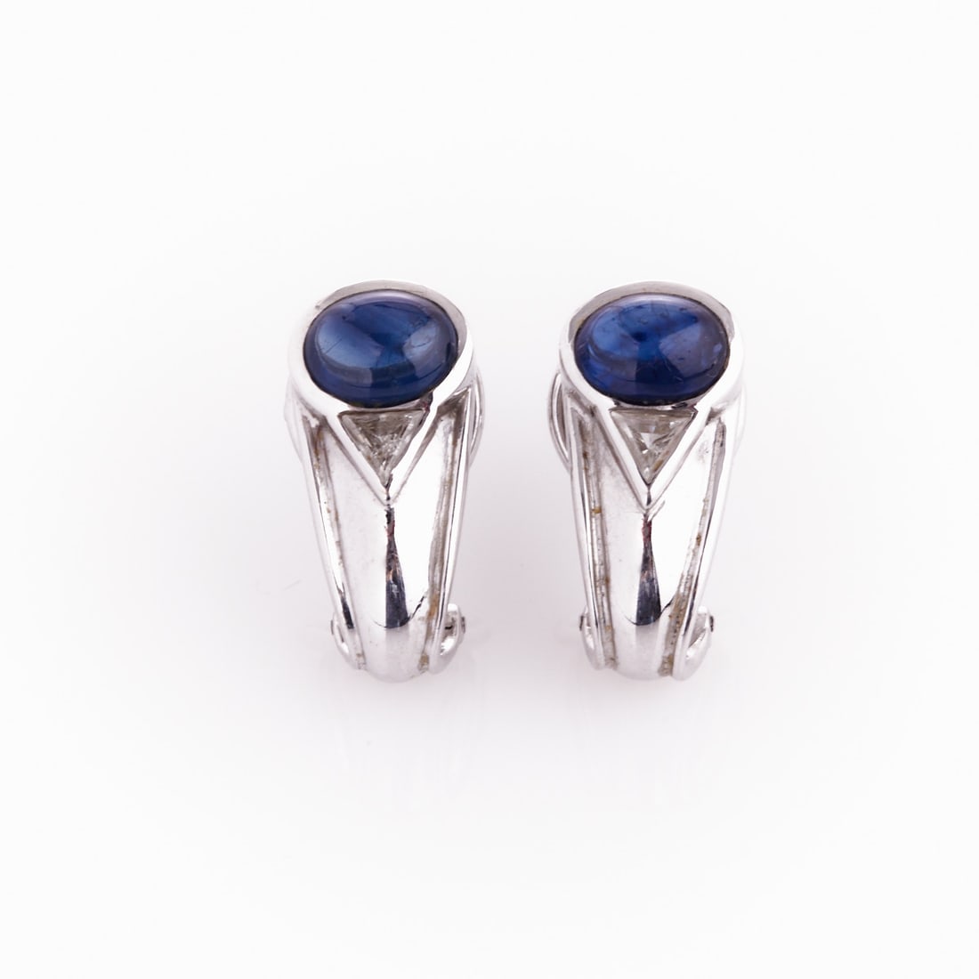Pair of Sapphire Hoop Earrings with Triangle Diamonds: Pair of Sapphire Hoop Earrings with Triangle Diamonds Handmade. 750/- white gold, stamped. Weight: 10.6 g. 2 star sapphires in cabochon cut totaling approx. 1.8-2 ct (7.8 x 6 x 3.9 mm). 2