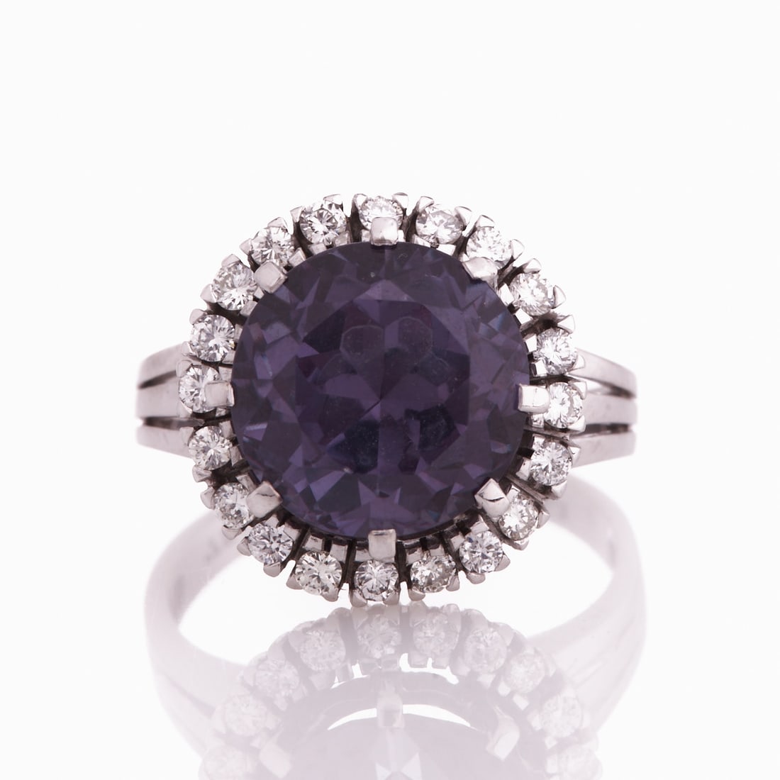 Ring with Brilliant Halo: Ring with brilliant halo 750/- white gold, stamped. Total weight: 7.9 g. 1 blue-violet gemstone in round cut (D. 1.1 cm). Approx. 20 brilliant-cut diamonds totaling approx. 0.6 ct. Ring size 56. Very 