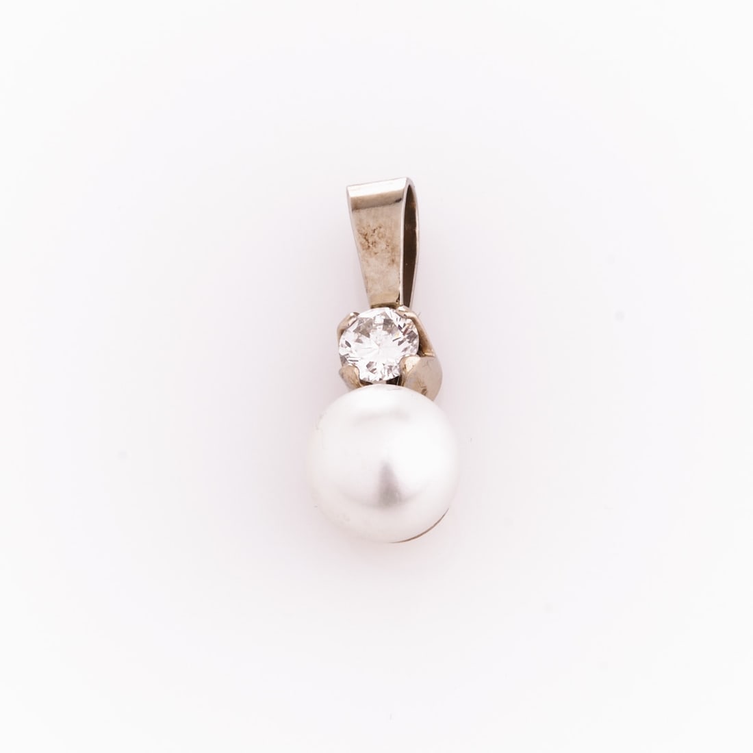 Classic pendant with diamond and pearl: Classic pendant with diamond and pearl 750/- white gold, stamped. Total weight: 2.3 g. 1 brilliant-cut diamond approx. 0.35 ct. 1 cultured pearl (D. 0.84 cm). Pendant length: 2.3 x 0.83 cm. Very good 