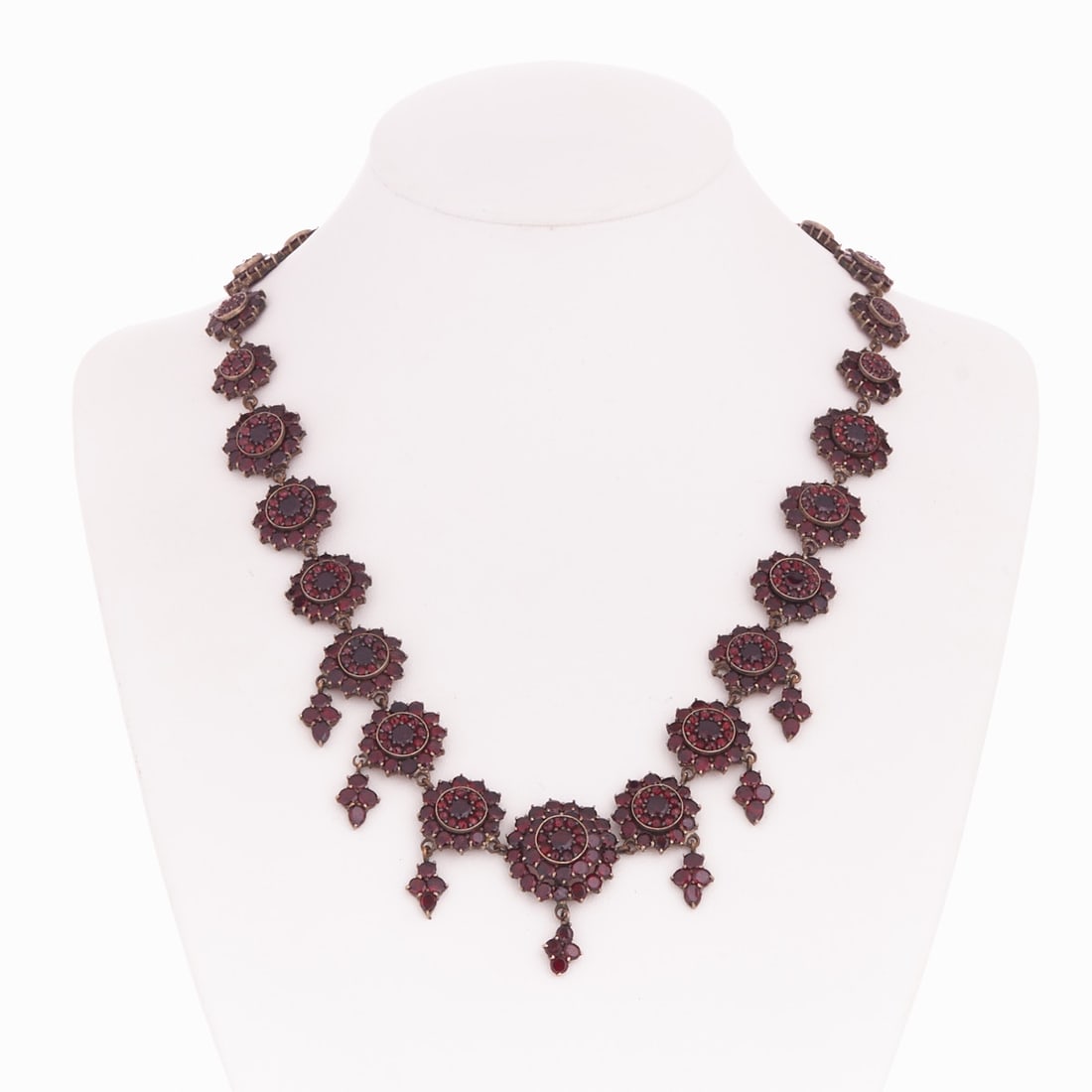 Garnet necklace and cross pendant: Garnet necklace and cross pendant Biedermeier, Bohemia around 1880. Tombac, non-gilded, gilded. Various garnets. Chain weight: 36.9 g. L. 43 cm. W. 3 cm. Cross dimensions: 6.7 cm. 4 cm eyelet. Signs o
