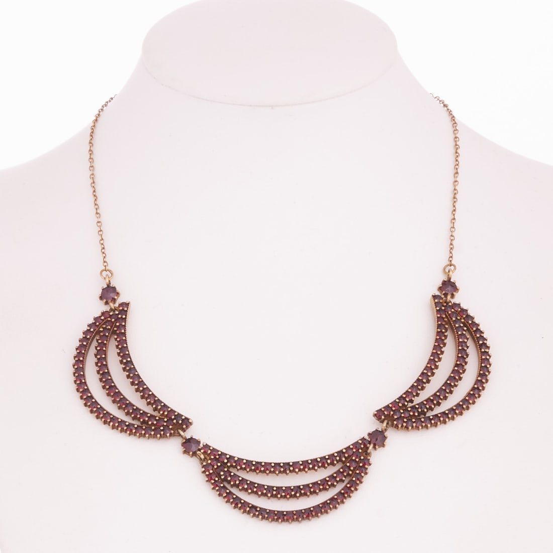 Garnet Necklace: Garnet Necklace Metal, gilded. Weight: 15.5 g. Various garnet stones. L. 37 cm. Slight age-related signs of wear. Decorative necklace with three large crescent-shaped elements, richly set with garnets