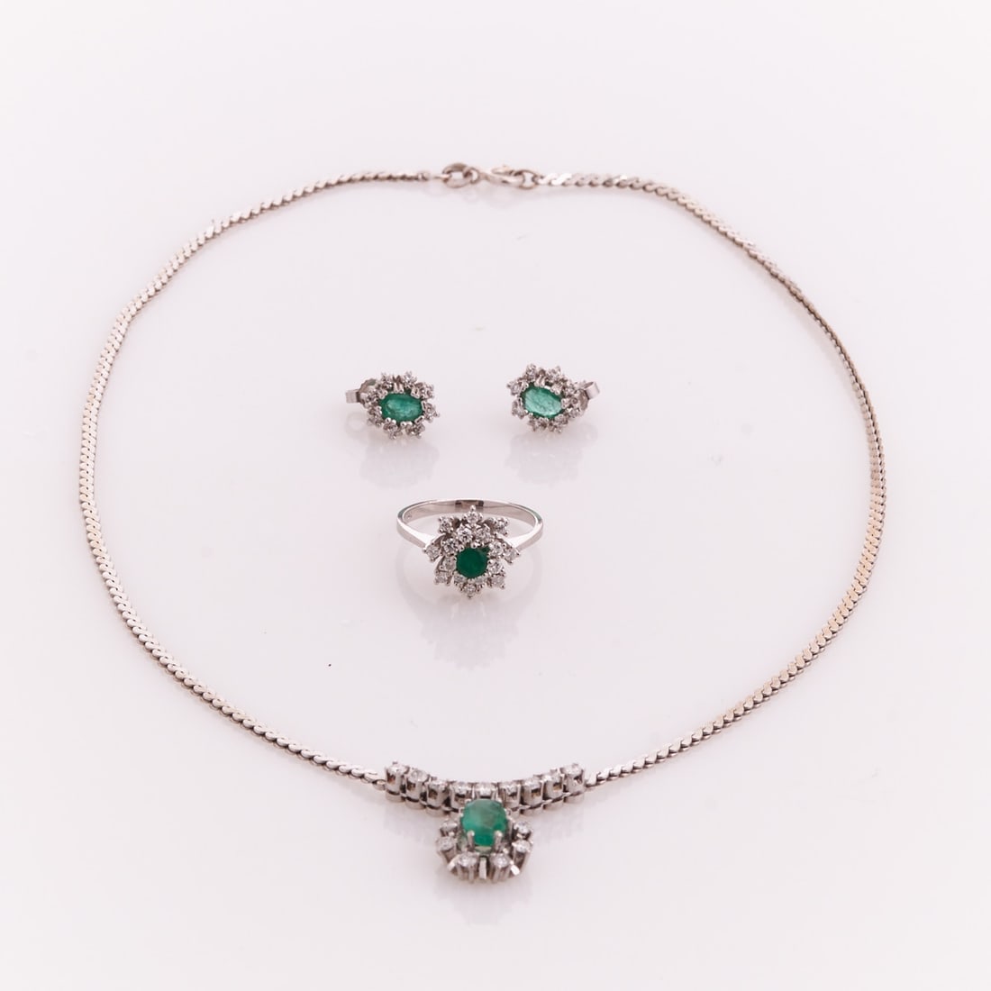 Emerald Jewelry Set: Necklace, Ring and Pair of Stud Earrings: Emerald Jewelry Set: Necklace, Ring and Pair of Stud Earrings 585/- white gold, stamped. Total weight: 17.9 g. Necklace: 1 oval cut emerald (7.8 x 5.4 x 2.8 mm), approx. 0.9 ct. 17 brilliant cut diamo