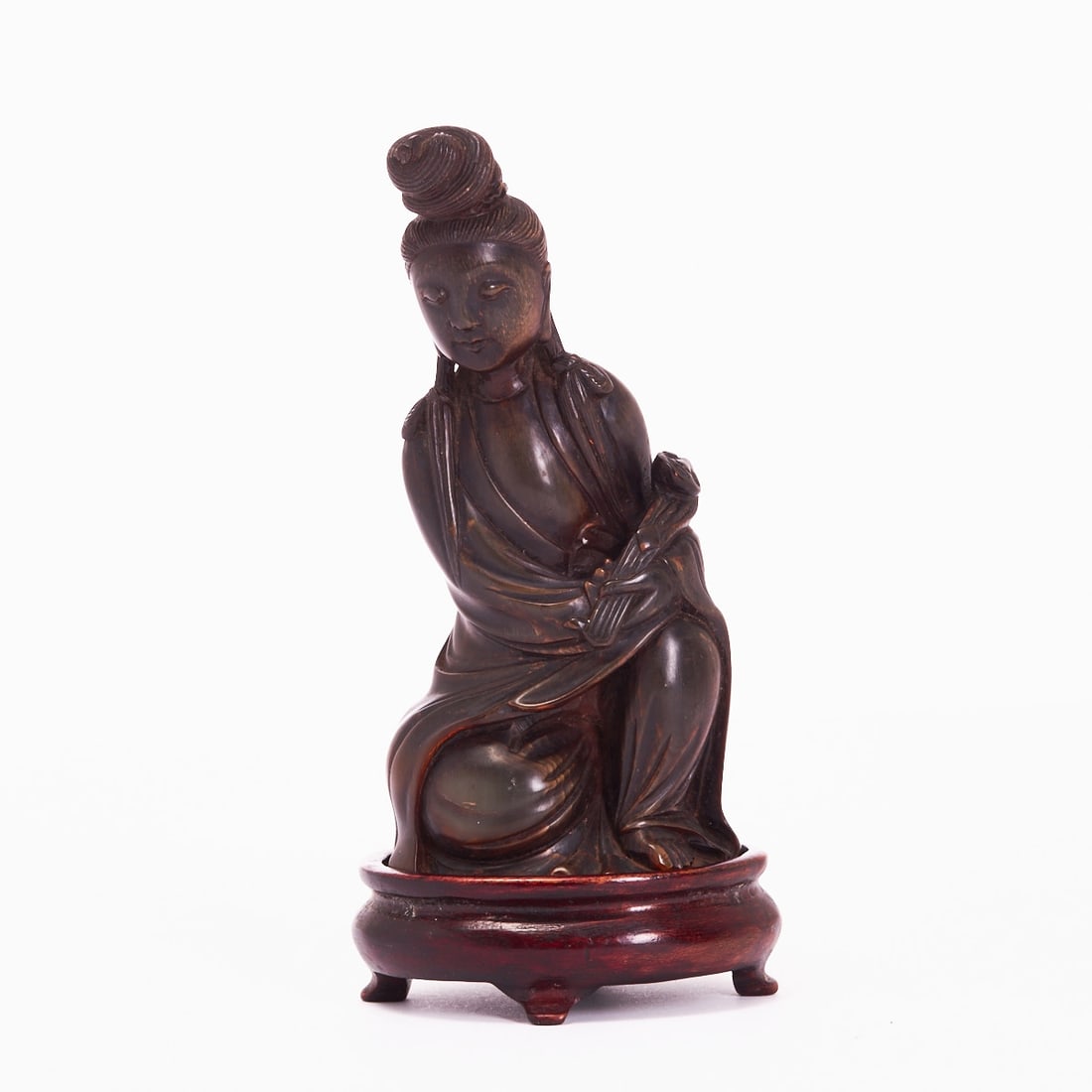 Carved Guanyin Figure with Wooden Base: Carved Guanyin figure with wooden base China, Qing Dynasty, probably 19th century or earlier. Finely crafted full-plastic representation of Guanyin made of dark brown horn, on a separately made wooden