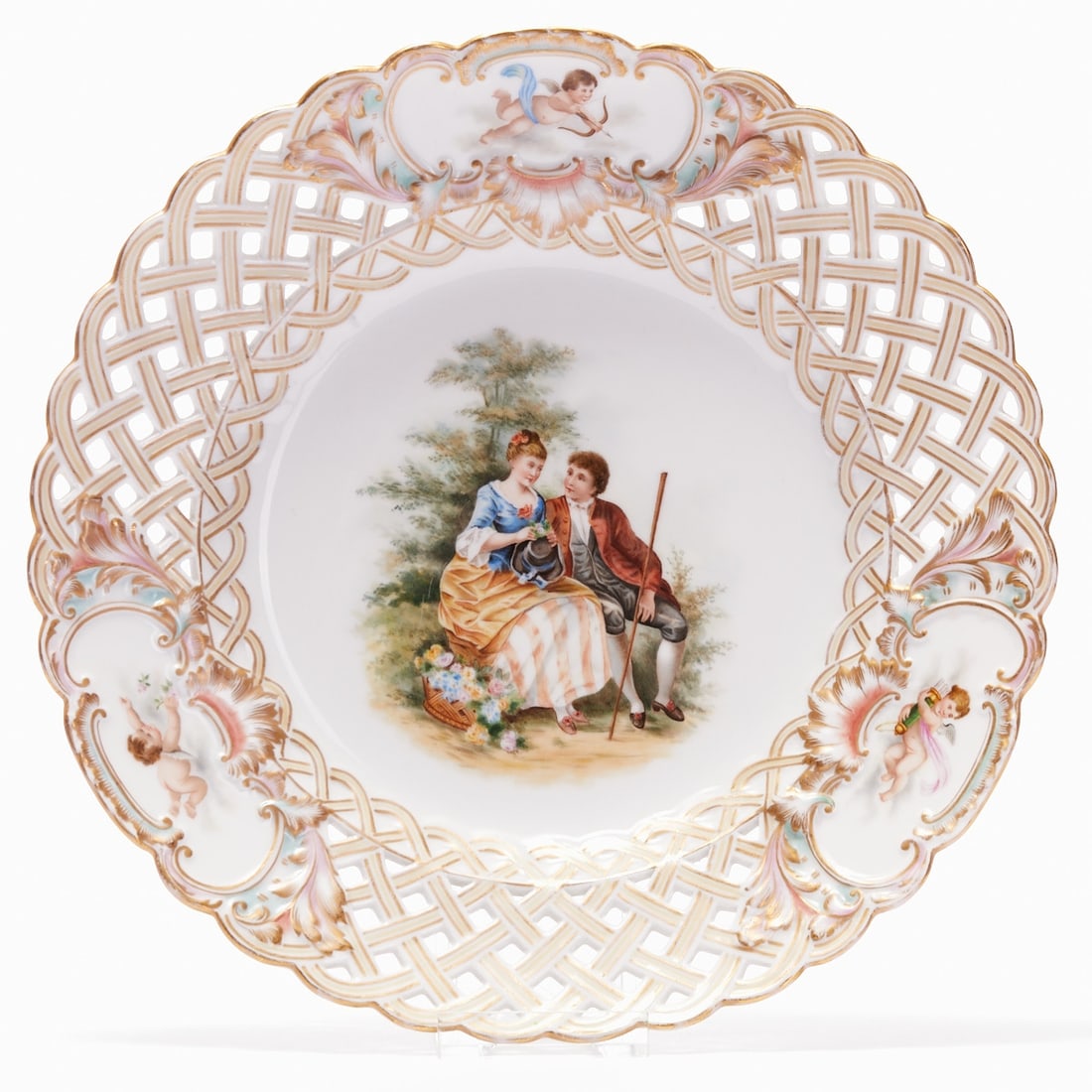 Pierced Plate - Shepherd Scene, Saxony or Thuringia, circa 1900: Pierced Plate - Shepherd Scene Saxony or Thuringia, circa 1900. Porcelain, white, glazed. Polychrome and gold painted. Gold rim. Courteous figure scene in the center. The rim with putti depictions in 