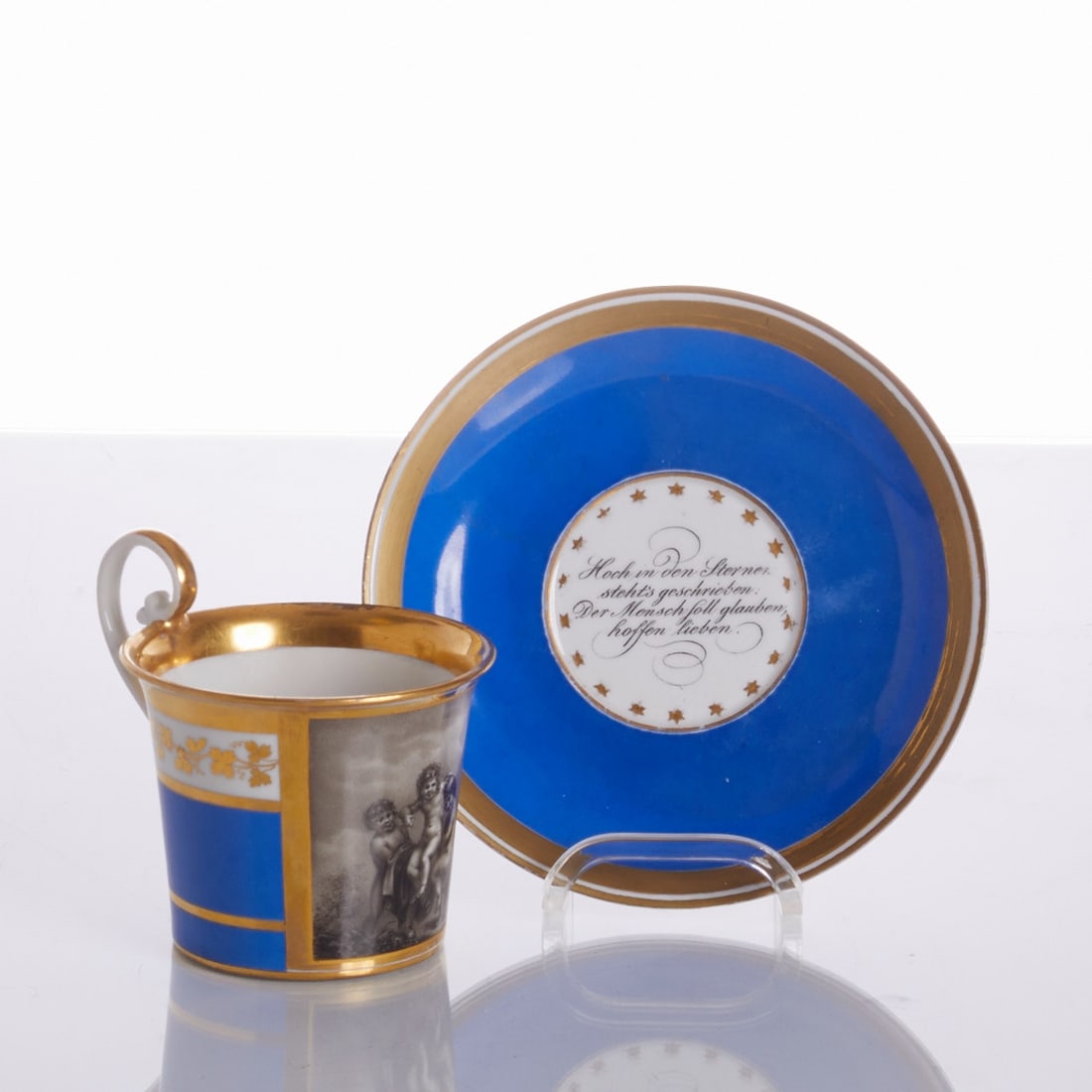 Cup with saucer - three putti and motto. Imperial Manufactory, Vienna 1826.: Biedermeier cup with saucer - three putti and motto Imperial Manufactory, Vienna 1826. Porcelain, white, glazed. Royal blue ground. Three putti in grisaille painting. Gold painted. Gold rim. Overcup: 