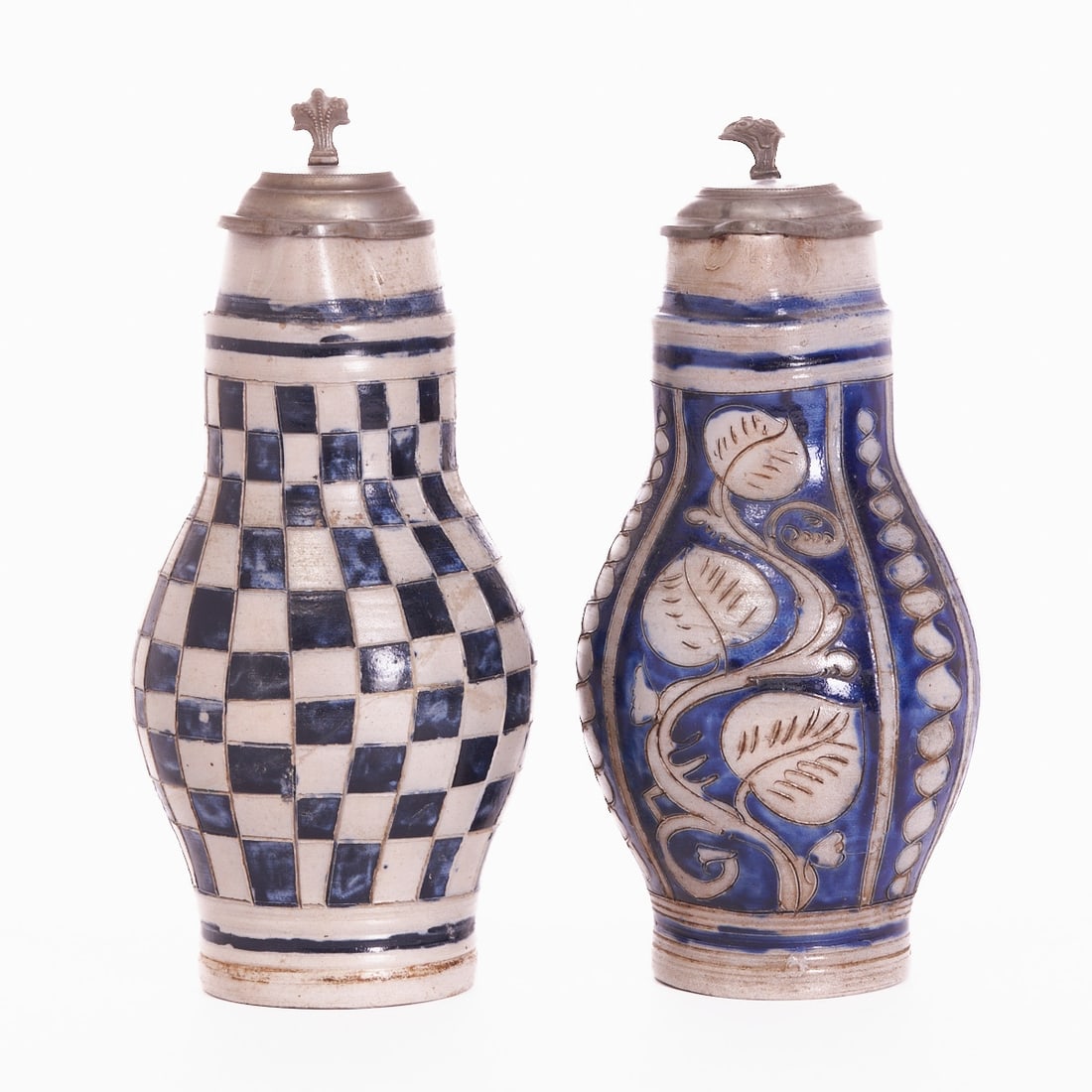 2 pear-shaped jugs - chessboard pattern and leafy tendril. Westerwald early 19th century.: 2 pear-shaped jugs - chessboard pattern and leafy tendril Westerwald early 19th century. Grey, salt-glazed stoneware with incised decoration, cobalt blue painting. Pewter mount with thumb rest and pew