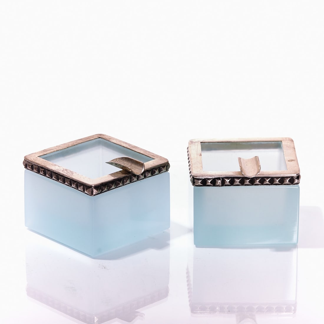 Pair of square ashtrays - Art D?©co. France, circa 1935-1940.: Pair of square ashtrays - Art Déco France, circa 1935-1940. Thick-walled, light blue opalescent glass, slightly translucent, cut and polished. Silver-colored mounting with an overlay and