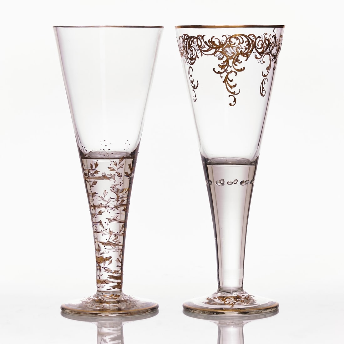 2 stemmed glasses with different gold painting. Gr?¤flich Schaffgotsch'sche Josephinenh??tte,: 2 stemmed glasses with different gold painting Gräflich Schaffgotsch'sche Josephinenhütte, Schreiberhau circa 1930. Colorless glass. Round disc foot, gold rim. Conical stem transitioning int