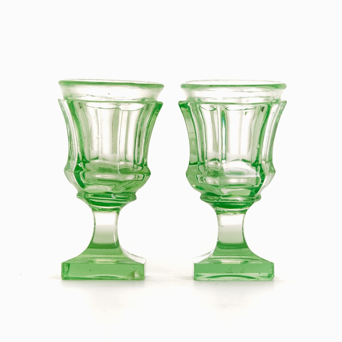 2 shot glasses. Circa 1900.: 2 shot glasses Circa 1900. Uranium glass: Green glass (apple green). Square foot with ground pontil mark. Stem faceted four times. Knop. Bell-shaped bowl, faceted six times, with inverted rim. H. 8 cm