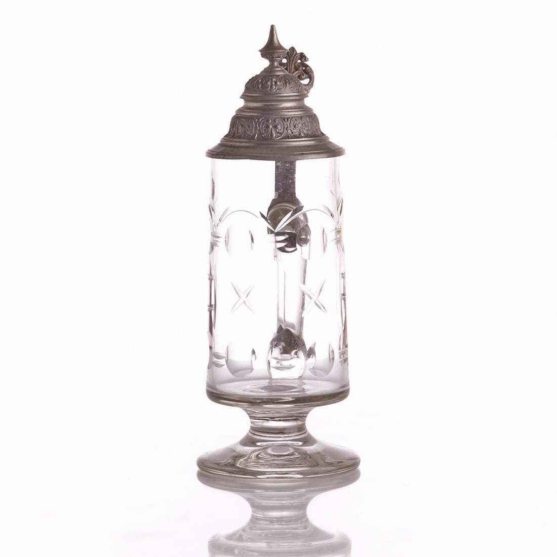 Jug.: Jug Colorless glass, engraved: Arches, circles, ovals, crosses. Fill line 0.5L. Pewter mounting with thumb rest and pewter lid. H. 26 cm. Provenance: From a North German private collection. - Conditio