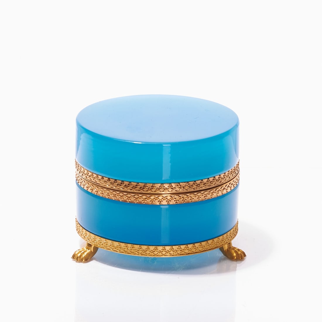 Round lidded box on mounting with lion's feet - Art Deco. France, circa 1935-1940.: Round lidded box on mounting with lion's feet - Art Deco France, circa 1935-1940. Thick-walled, blue opal glass, slightly translucent, cut and polished. Gilded, embossed brass mounting with hinge.