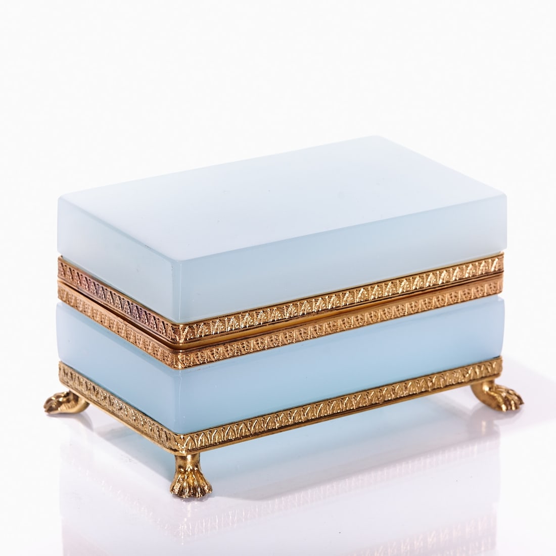 Rectangular lidded box on mounting with lion's feet - Art Deco. France, circa 1935-1940.: Rectangular lidded box on mounting with lion's feet - Art Deco France, circa 1935-1940. Thick-walled, light blue opal glass, slightly translucent, cut and polished. Gilt brass mounting with hinge.