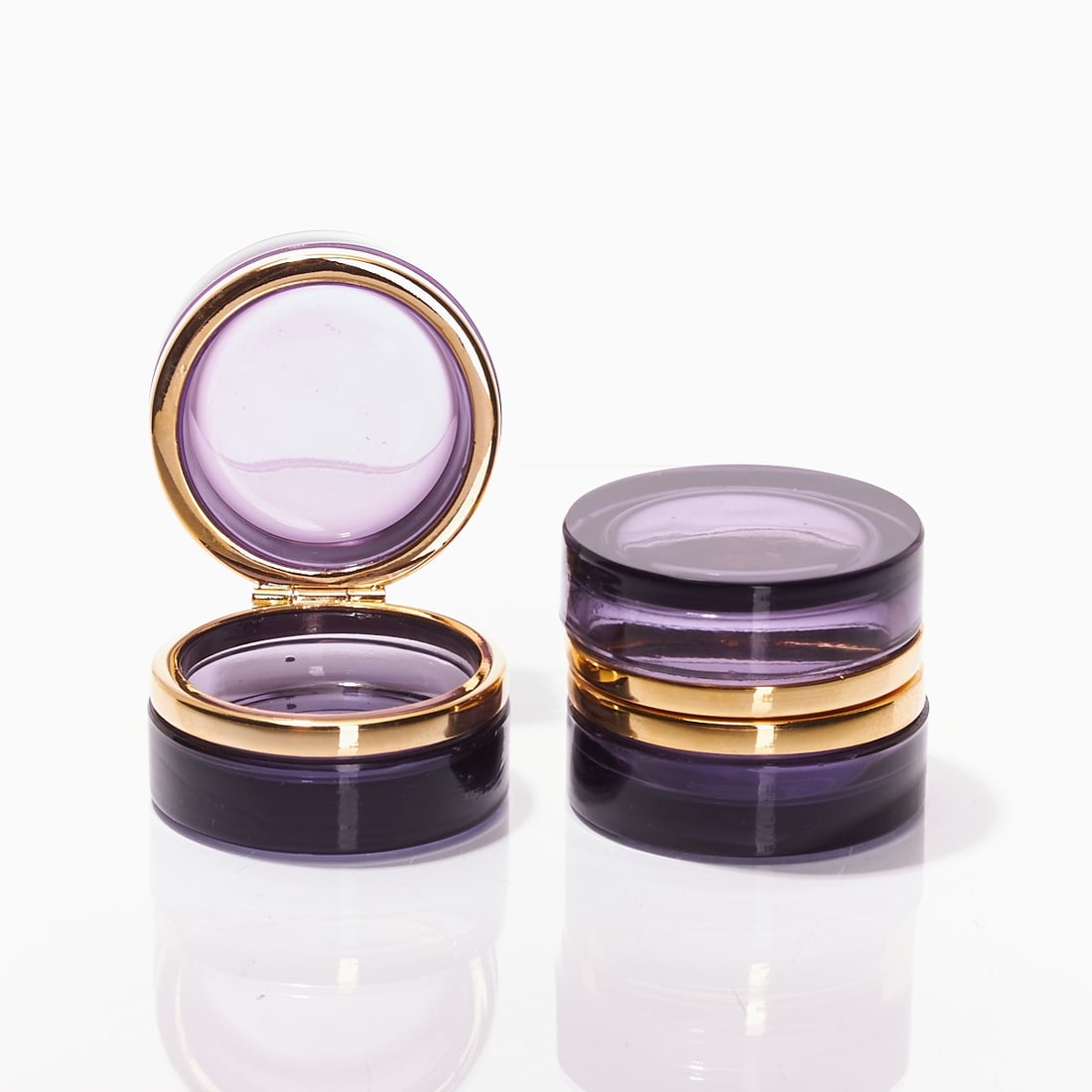 Pair of round lidded boxes - Art Deco. France, circa 1935-1940.: Pair of round lidded boxes - Art Deco France, circa 1935-1940. Thick-walled, violet glass, cut and polished. Gilt brass mounting with hinge. H. 4.5 cm, D. 6 cm.