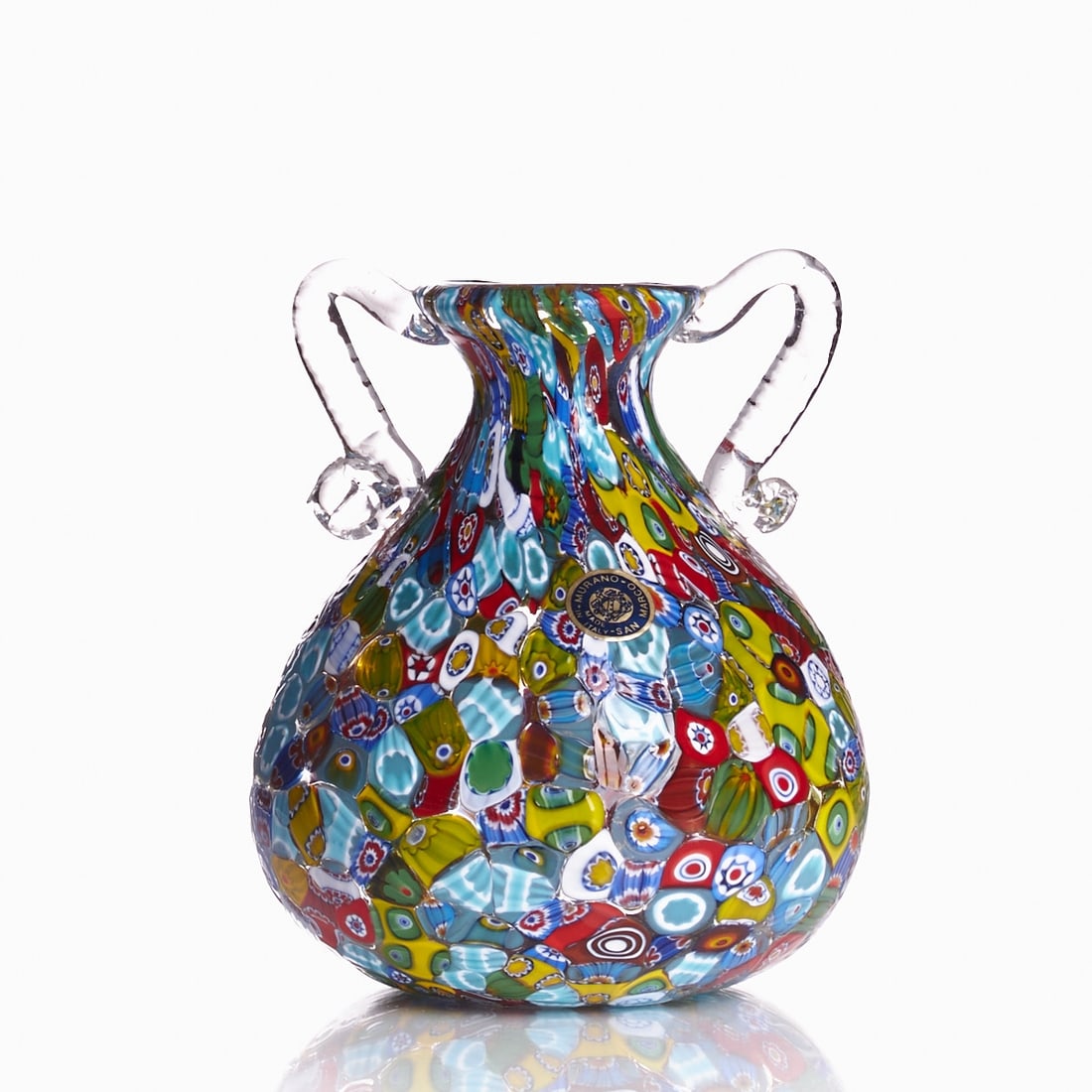 Vase with handles - Millefiori. San Marco, Murano.: Vase with handles - Millefiori San Marco, Murano. Colorless glass with melted-in Millefiori rods. Handles made of colorless glass. Paper sticker: MURANO SAN MARCO MADE IN ITALY. Pontil mark. H. 14 cm.