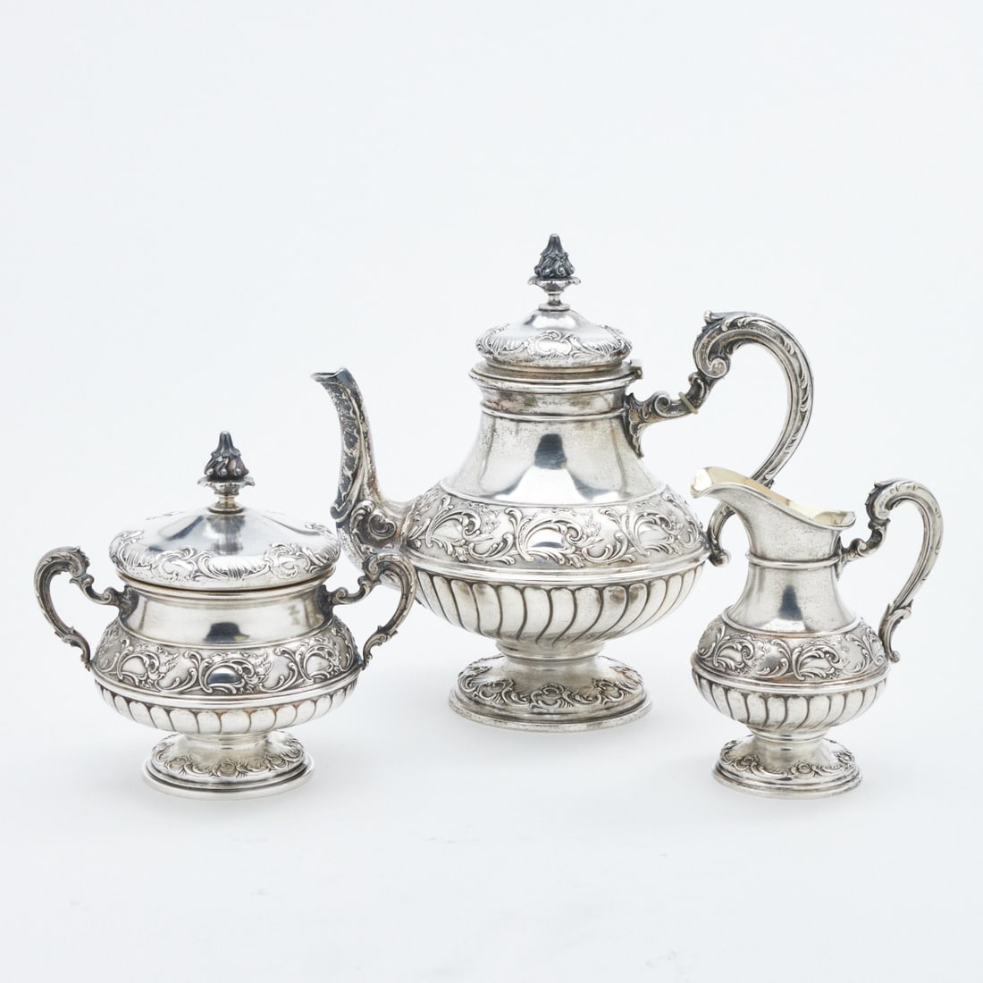 3-piece tea set in Historicism style: 3-piece tea set in Historicism style Wilkens/Bremen. 800 silver. Hallmarks: maker's mark, 800, crescent/crown, Th. Blume. Weight: 962 g. 1 Teapot H. 21.5 cm. 1 Milk jug H. 12.3 cm. 1 Sugar bowl H.