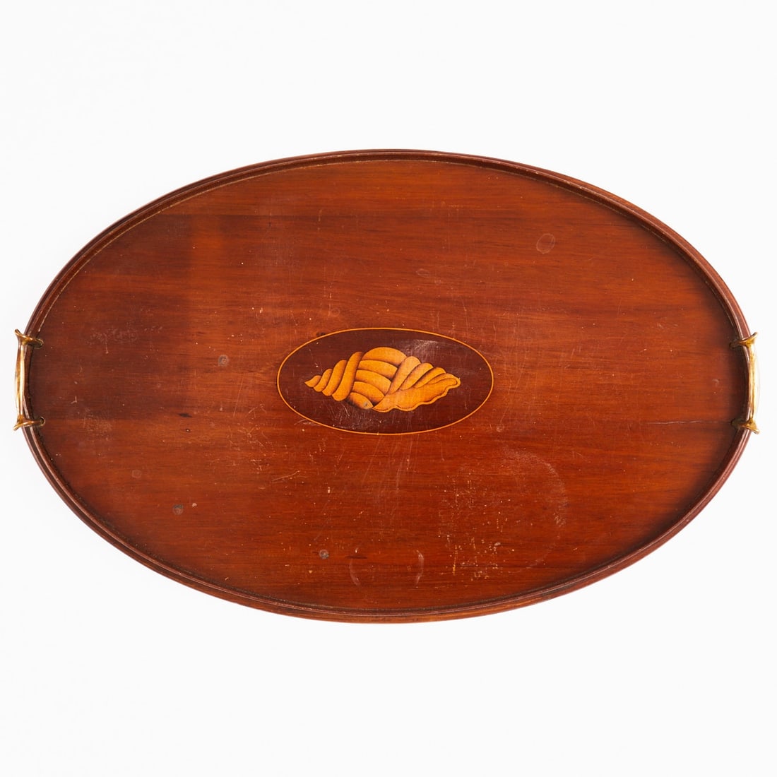 Decorative Wooden Tray with Inlays: Decorative wooden tray with inlays England, circa 1900. Wood. D. 58 cm. Oval tray with profiled edge and two side brass handles. In the center, an inlaid depiction of a shell in various colored woods,