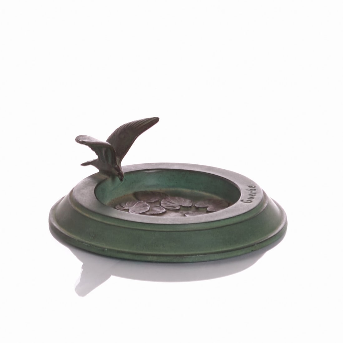 Ashtray 'Guerbe': Art Nouveau ashtray Probably around 1900. Cast metal with green patinated surface and bronze-accentuated relief decor. Round shape with sculpturally applied bird over stylized water lily leaves. Signe