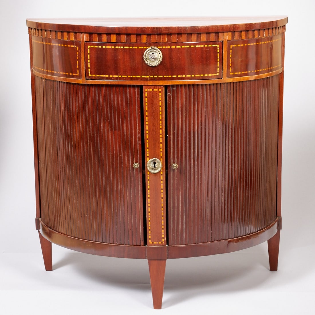 Side Commode, so-called Demi-Lune: Side Commode, so-called Demi-Lune England, 19th century. Mahogany. Fruitwood. 80 x 41 x 79 cm. Good condition.