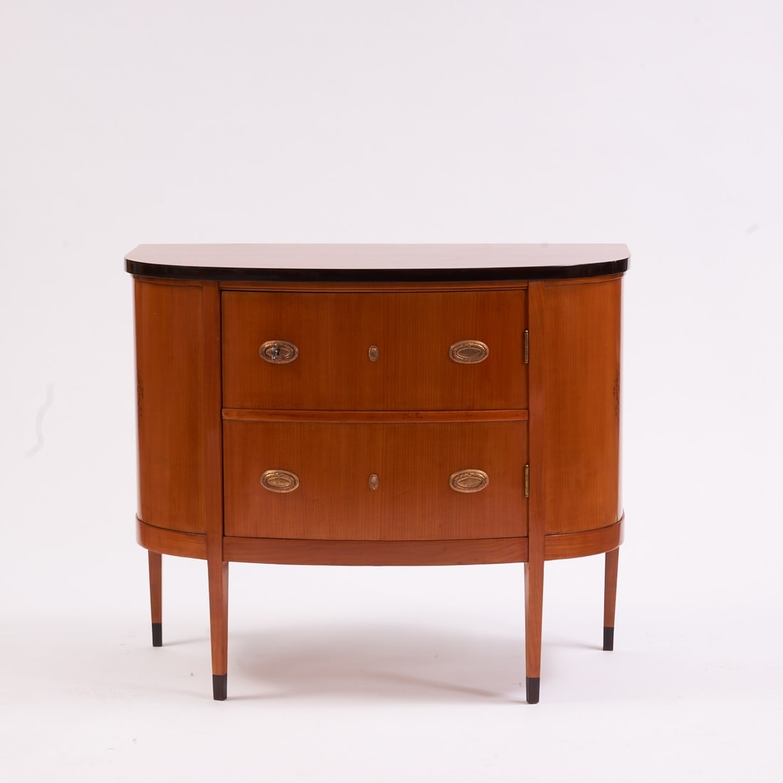 Art Deco Demilune: Art Deco Demilune Germany, circa 1900. Cherry. 85 x 100 x 80 cm. On four conical feet. Rectangular, bombé body with one door. Ebonised medallions on the sides.
