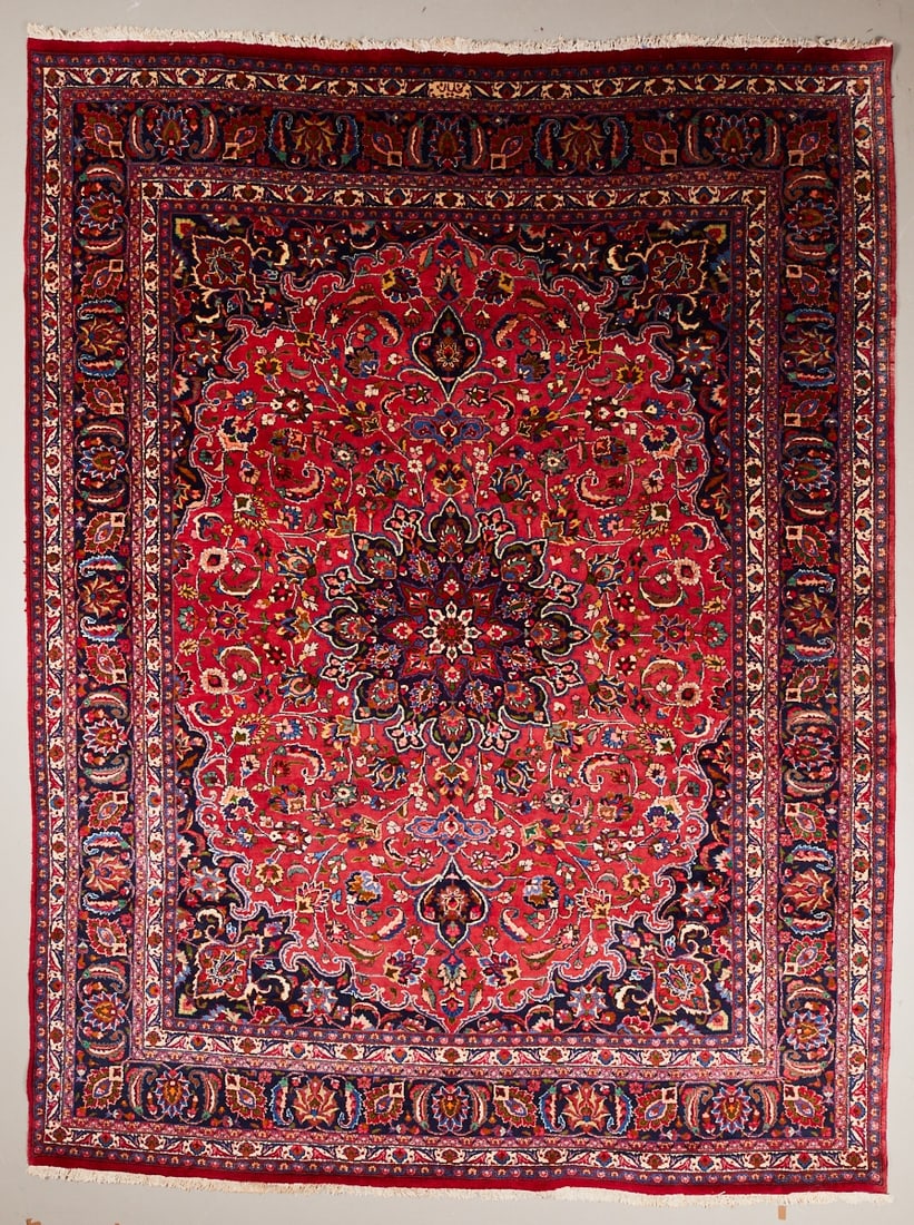 Mashhad Carpet: Mashhad CarpetPersia, 20th century. Wool on cotton, approx. 392 x 301 cm. Signed. Hand-knotted carpet with a strong rosé-red central field and a large central floral medallion in dark blue,