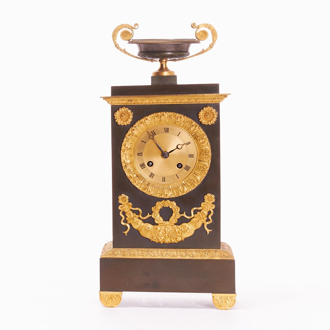 Empire Pendulum Clock: Empire Pendulum Clock France, circa 1820. Gilt and brown patinated bronze. 37.4 x 16.7 x 9 cm. Thread suspension. Pendulum. Roman numerals. Inscribed on the plate. Movement and function without
