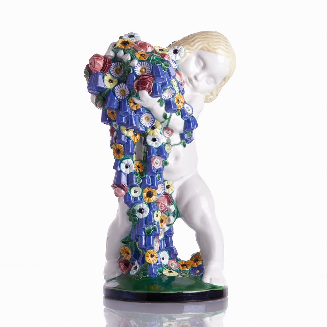 Michael Powolny. Putto with Flowers (Spring) - Execution: Wiener Keramik, c. 1907.: Putto with Flowers (Spring) - Michael Powolny Michael Powolny - Execution: Wiener Keramik, c. 1907. Earthenware, white body, polychrome glazed. On the base, two embossed marks: Wiener Keramik and arti
