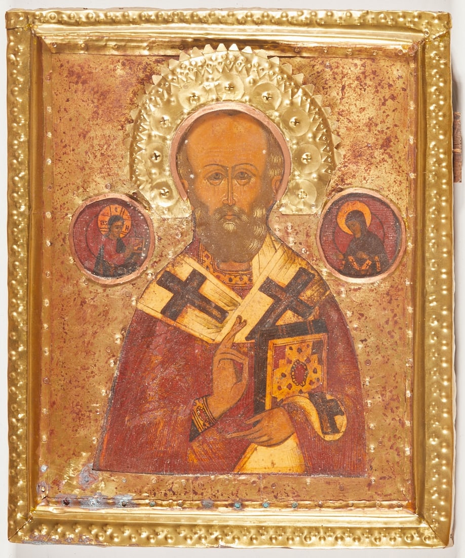 Icon: Icon Russia, circa 1900. -Saint Nicholas- Tempera on chalk ground on wood, brass oklad with copper, 30.7 x 25.5 cm. Verso two splines (one missing). Rubbed and traces of age.