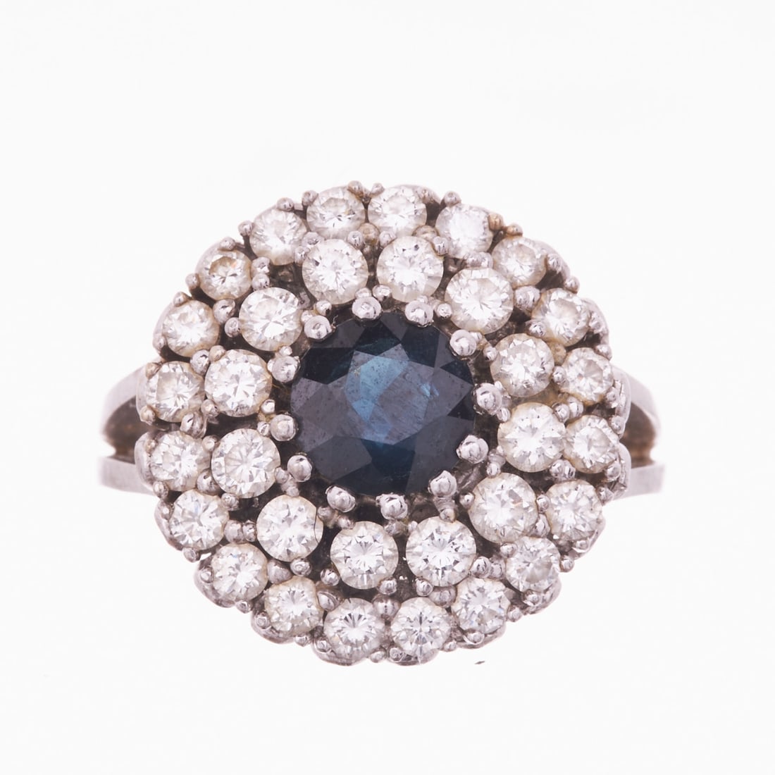 Flower-shaped sapphire ring surrounded by brilliant-cut diamonds: Flower-shaped sapphire ring surrounded by brilliant-cut diamonds 20th century. 585/- white gold, hallmarked. Weight 10.1 g. Centrally set round-cut sapphire of approx. 1.47 ct, flower-shaped