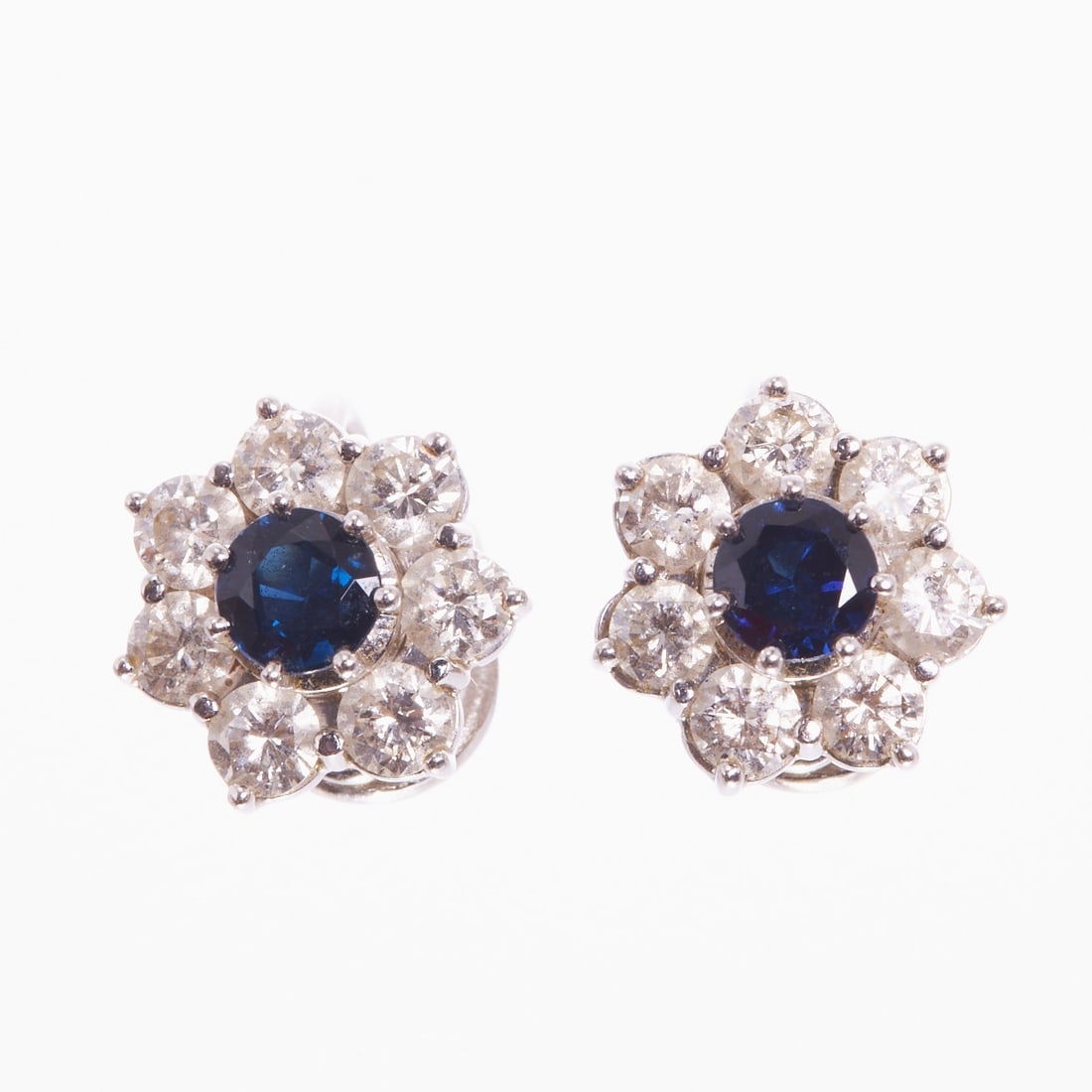 Pair of Flower-Shaped Sapphire and Brilliant-Cut Diamond Ear Clips: Pair of flower-shaped sapphire and brilliant-cut diamond ear clips 585/- white gold, unmarked, tested. Total weight: 4.4 g. 2 sapphires in round cut totaling approx. 0.80 ct. 14 brilliant-cut