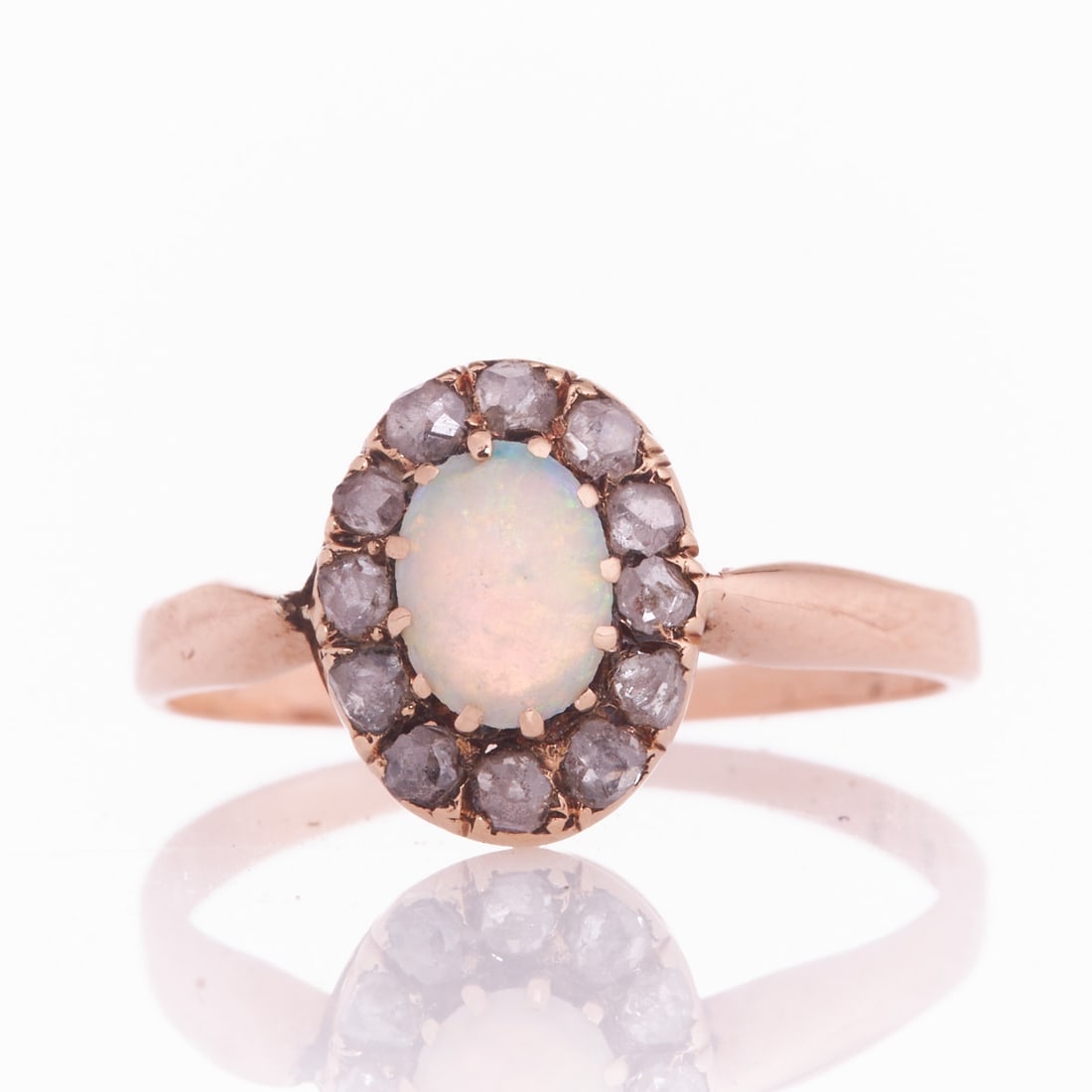 Simple Opal Ring with Beautiful Play of Color: Antique Opal Ring with Rose-Cut Diamonds Circa 1900. 585/- rose gold, stamped. Weight: 1.9 g. 1 cabochon-cut opal (0.6 x 0.4 cm). Ring size 53. Signs of wear. Simply crafted ring with a cabochon-cut