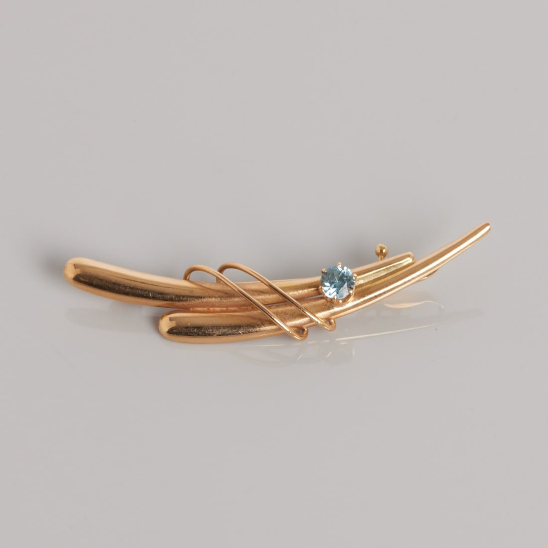 Brooch: Brooch 585/- rose gold, stamped. Weight: 2.3 g. Hallmarks: EH, 585. 1 blue stone. Dimensions 5 x 1 cm. Good condition.