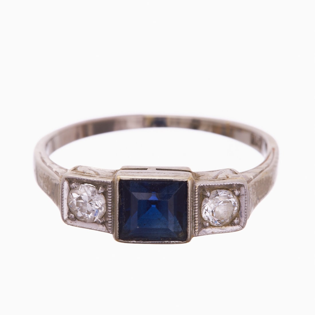 Sapphire-Diamond Ring: Sapphire-Diamond Ring 750/- white gold, stamped. Total weight: 2.7 g. Centrally set square-cut sapphire approx. 0.5 ct. 2 old-cut diamonds totaling approx. 0.2 ct. Ring size 53. Signs of age and