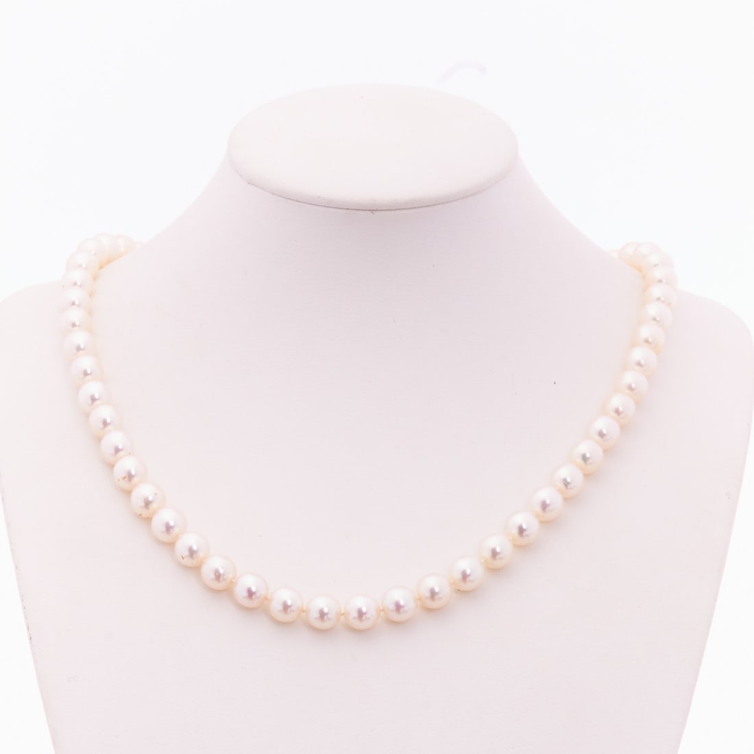 Cultured pearl necklace with white gold clasp: Cultured pearl necklace with white gold clasp 750/- white gold, stamped. Weight: 32.2 g. 55 cultured pearls (D. 0.7 cm). L. 44.5 cm. Box clasp. Very good preservation. Beautiful luster and uniform