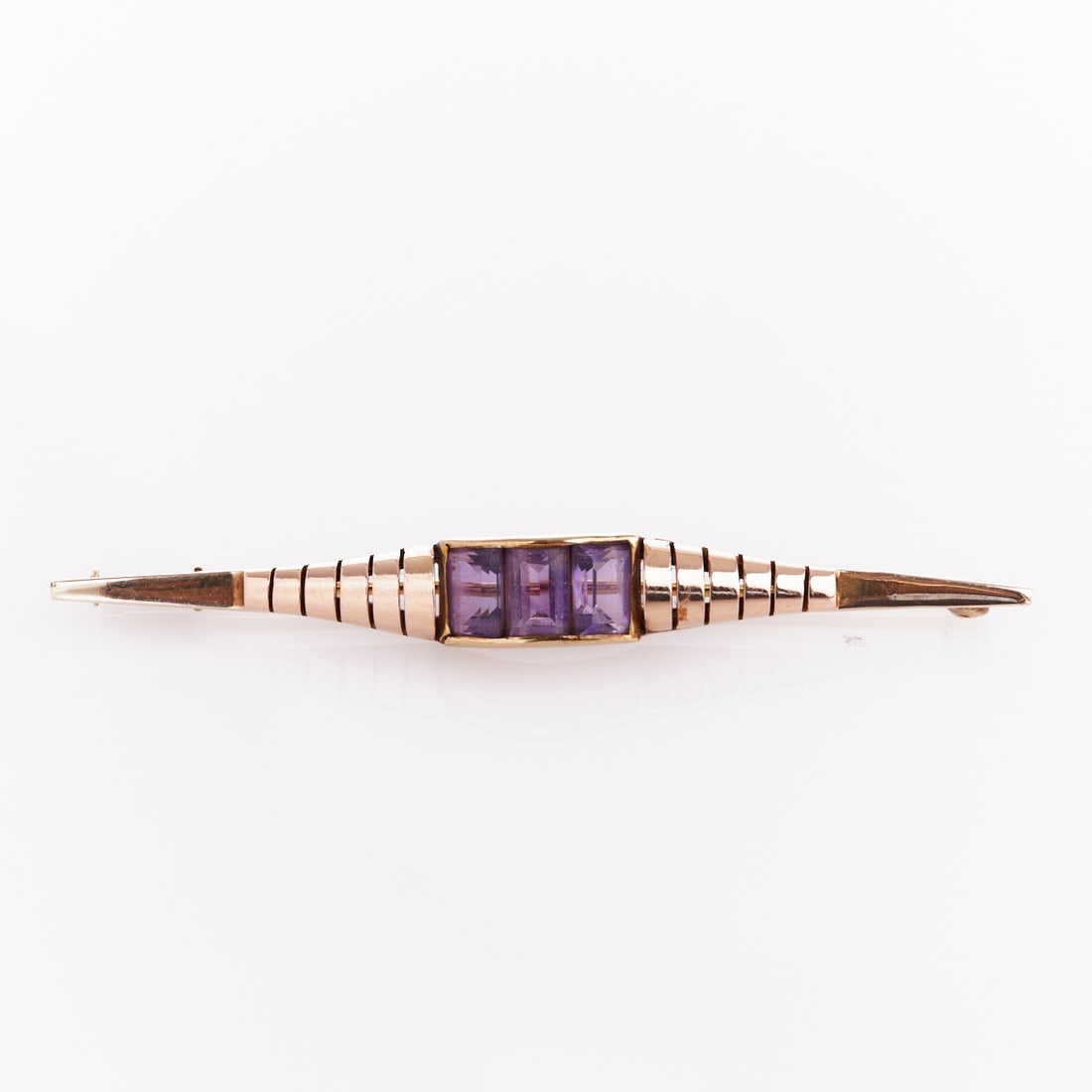 Amethyst Pin: Amethyst Pin Mid-Century, approx. 1940-1950. 585/- yellow gold, stamped. Weight: 4.8 g. 3 rectangular-cut amethysts, each (6 x 4 x 3.1 mm). L. 6.2 cm. W. 0.7 cm. Pin with safety clasp. Good condition.