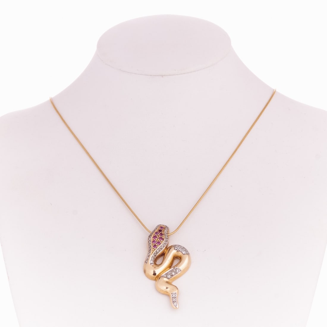 Serpentine Pendant on Chain: Serpentine pendant on chain 585/- yellow gold, hallmarked. Total weight: 14.5 g. Hallmark: Christ. 9 rubies totaling approx. 0.27 ct. Various 8/8-cut diamonds. Pendant dimensions: 4.5 x 2.2 cm. Chain