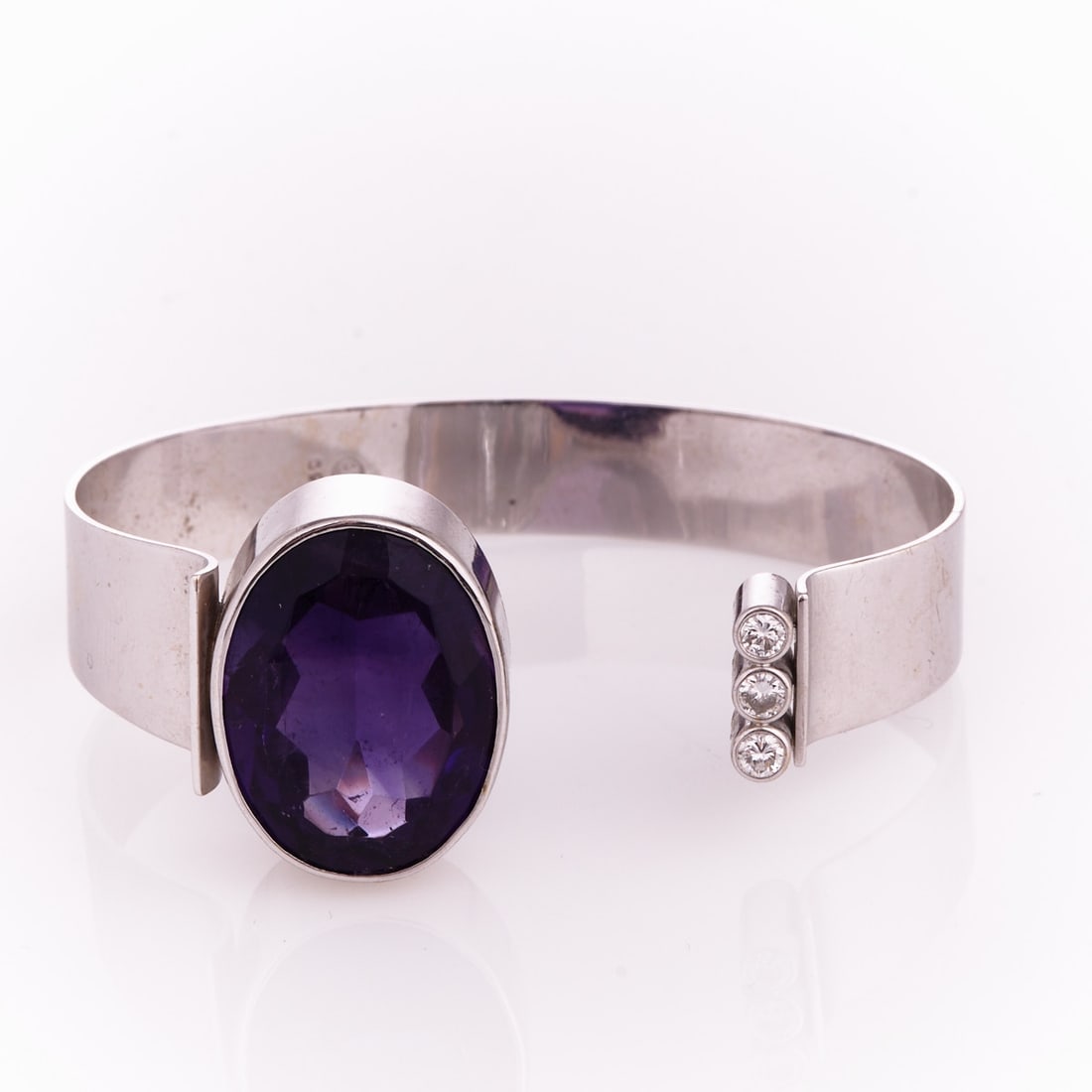 Amethyst bangle: Amethyst bangle Goldschmiede Herbert Bitter, Hanover. 750/- white gold, stamped. Weight: 35.3 g. Hallmark: 750 HB in a circle. 1 oval cut amethyst totalling approx. 24 ct. 3 brilliant-cut diamonds