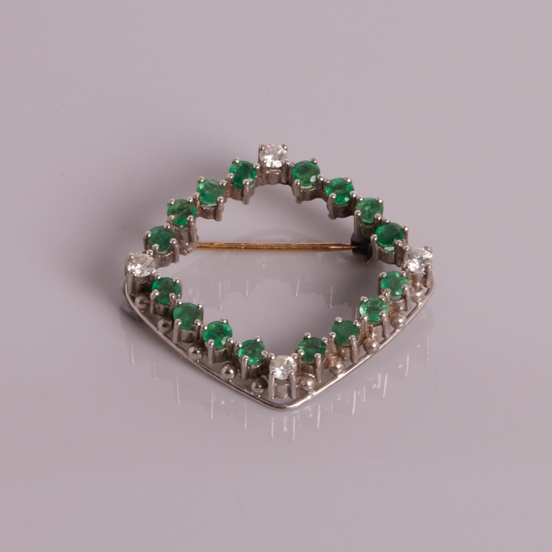 Brooch with emeralds and brilliant-cut diamonds: Brooch with emeralds and brilliant-cut diamonds 750/- white gold, unstamped, tested. Weight: 6.6 g. 4 brilliant-cut diamonds totalling approx. 0.3-0.4 ct. 16 round-cut emeralds totalling approx. 1.6 c