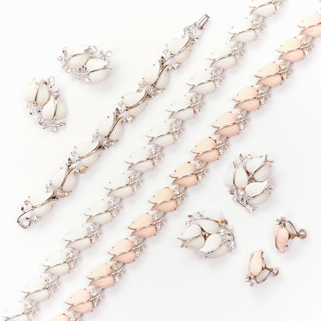 LISNER - Two Vintage Jewelry Sets with Tulip Motif (6 pieces): LISNER - Two Vintage Jewelry Sets with Tulip Motif (6 pieces) 2 necklaces, 1 bracelet and 3 pairs of ear clips. Lisner, New York, circa 1950. Metal, silver-colored with white/pink thermoset plastic