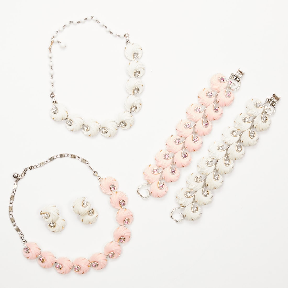 LISNER - Vintage Thermoset Parure with Feather Motif in Pink and White (5 pieces): LISNER - Vintage Thermoset Parure with Feather Motif in Pink and White (5 pieces) 2 necklaces, 2 bracelets and 1 pair of ear clips. Lisner, New York, circa 1950. Metal, silver-colored with crystal and