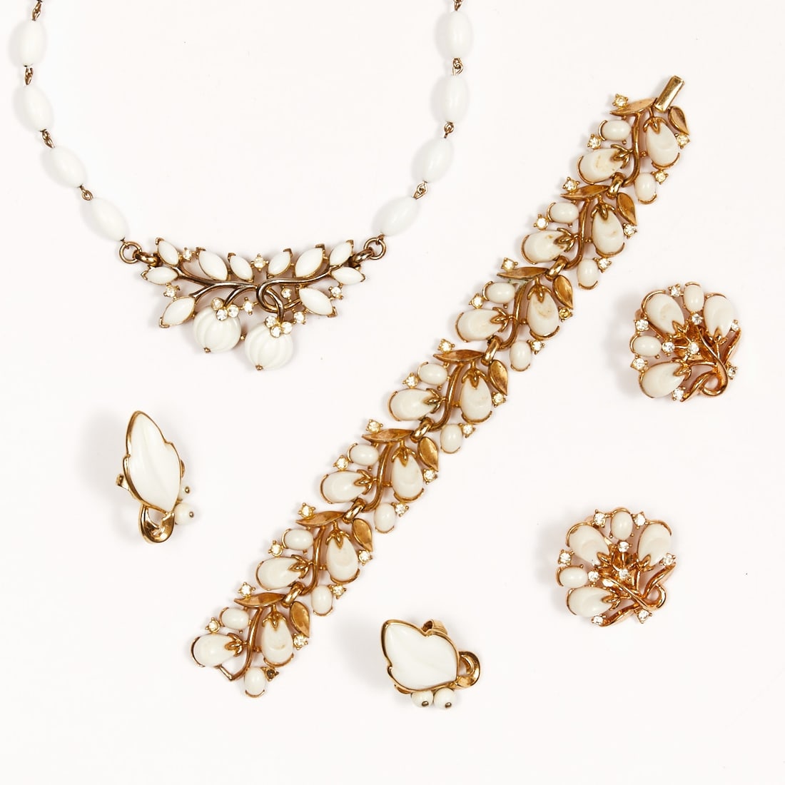 TRIFARI Alfred Philippe - Vintage ''Pebble Beach'' jewelry set (4 pieces): TRIFARI Alfred Philippe - Vintage ''Pebble Beach'' jewelry set (4 pieces) Necklace, bracelet, and 2 pairs of ear clips. New York, 1956. Metal, gold-colored with rhinestones and white thermoset. Weight