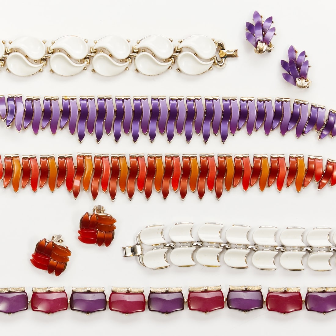 LISNER - Three Vintage Thermoset Parures in White/Purple/Red Tones (7 pieces): LISNER - Three vintage thermoset parures in white/purple/red tones (7 pieces) 3 colliers, 2 bracelets and 2 pairs of ear clips. Lisner, New York, circa 1950. Metal, white gold colored; Lucite. Total w