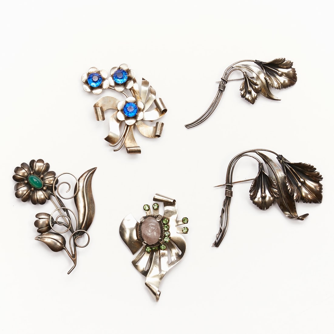 Five Vintage Designer Sterling Brooches: Five vintage designer sterling brooches Probably USA, 1940s. 925/- sterling silver. Faux jade. Blue and green rhinestones. Total weight: 110 g. Dimensions: 7 x 10 cm. / 5.5 x 8.3 cm. / 9.5 x 4 cm / 7 