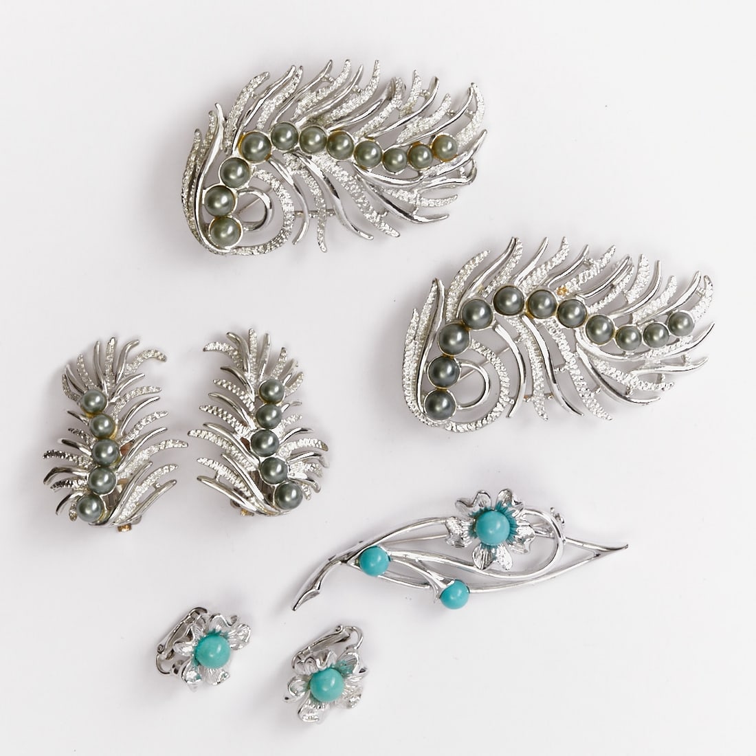 SARAH COVENTRY - Two Vintage Brooch-Ear Clip Jewelry Sets with Feather Motif (5 pieces): SARAH COVENTRY - Two Vintage Brooch-Ear Clip Jewelry Sets with Feather Motif (5 pieces) 3 brooches and 2 pairs of ear clips. Sarah Coventry Co., USA; circa 1960. Metal, silver-colored. Faux pearls. We