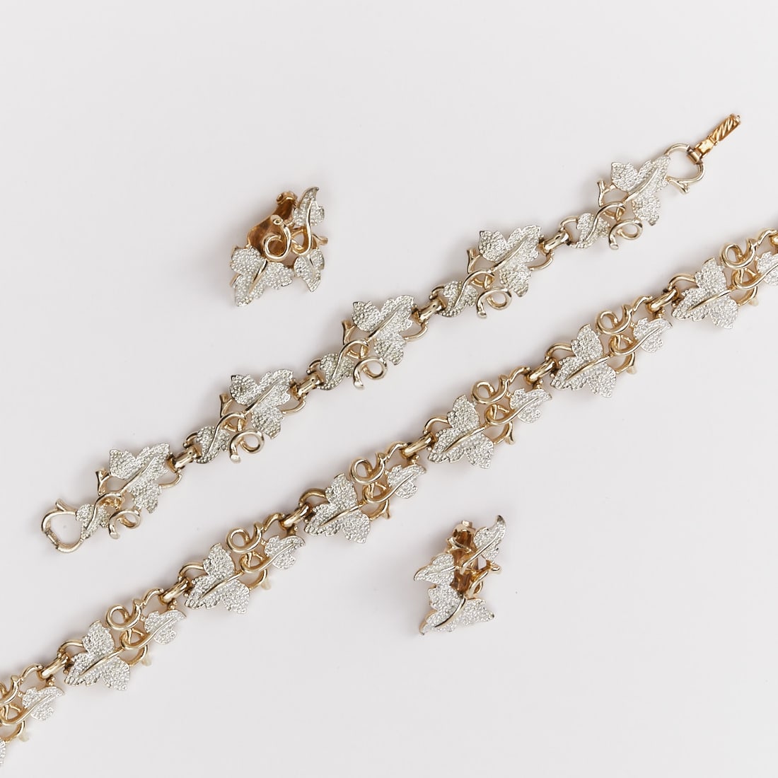 SARAH COVENTRY - Two vintage jewelry sets with leaf motif (6 pieces): SARAH COVENTRY - Two vintage jewelry sets with leaf motif (6 pieces) 2 necklaces, 2 bracelets and 2 pairs of clip earrings. Sarah Coventry company, USA; circa 1960. Metal, gold and silver colored. Wei