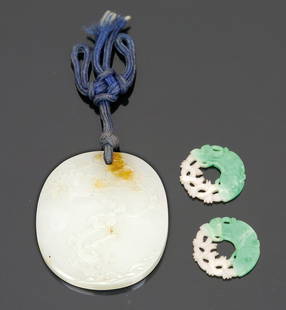 Medaillon und zwei kleine Anhänger China. Jad...: Medaillon und zwei kleine Anhänger China. Jade. 5,5 x 4,5 cm. Bzw. D. 2,5 cm. Ovales Medaillon mit reliefierter Kirschbaumdarstellung. Die kleinen, zweifarbigen Anhänger mit Durchbruchdekor.