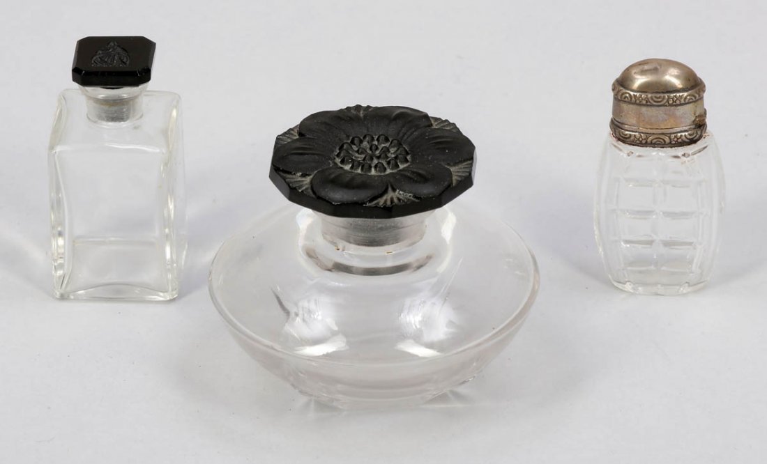 3 Flakons u.a. Jeanne Lanvin, Frankreich....: 3 Flakons u.a. Jeanne Lanvin, Frankreich. Farbloses Glas, formgepresst. Zwei Flakons mit Stpsel aus violettem Glas. 1 Flakon, Stpsel mit Emblem Lanvin. Unter dem Stand bez.: Lanvin France BR4 (H. 5,5 