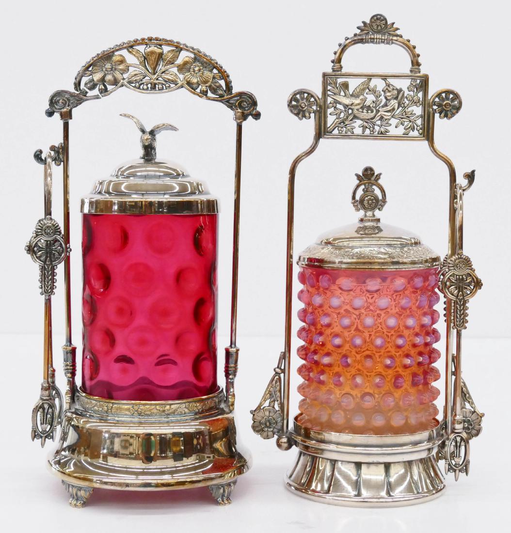 2pc Victorian Glass Pickle Castors. Includes a: 2pc Victorian Glass Pickle Castors. Includes a cranberry thumbprint castor 10.5''x5.5''. Also an opalescent hobnail glass castor 11''x5.5''. One silverplated frame has break to top handle. Hobnail gla